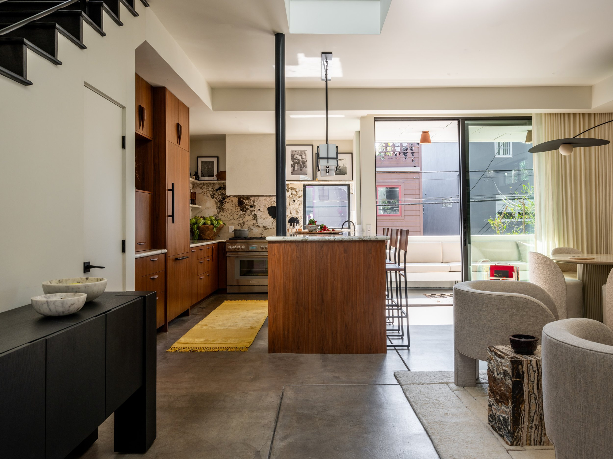 Open Venice Canals kitchen with walnut cabinetry, a stone backsplash and a yellow vintage runner